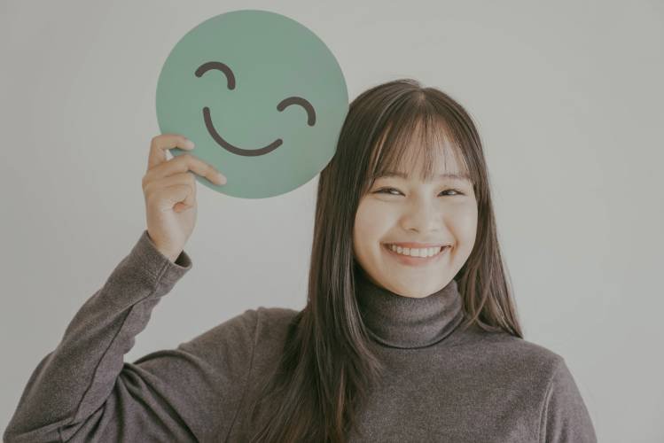happy-young-asian-woman-holding-smile-emoji-face-2024-10-18-04-56-50-utc.jpg